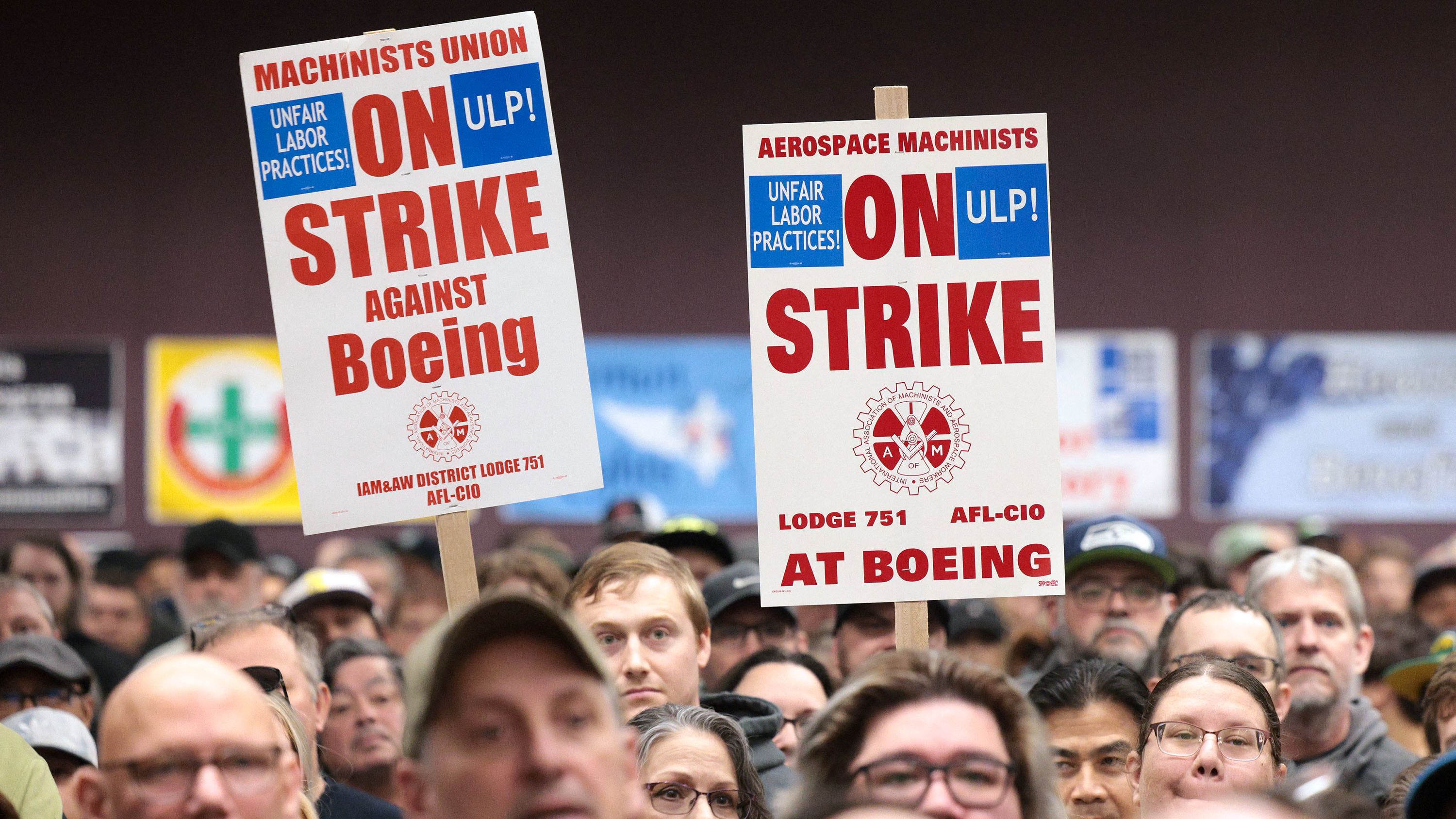 People hold signs during a strike rally for the International Association of Machinists and Aerospace Workers (IAM) at the Seattle Union Hall in Seattle, Washington, on October 15, 2024.