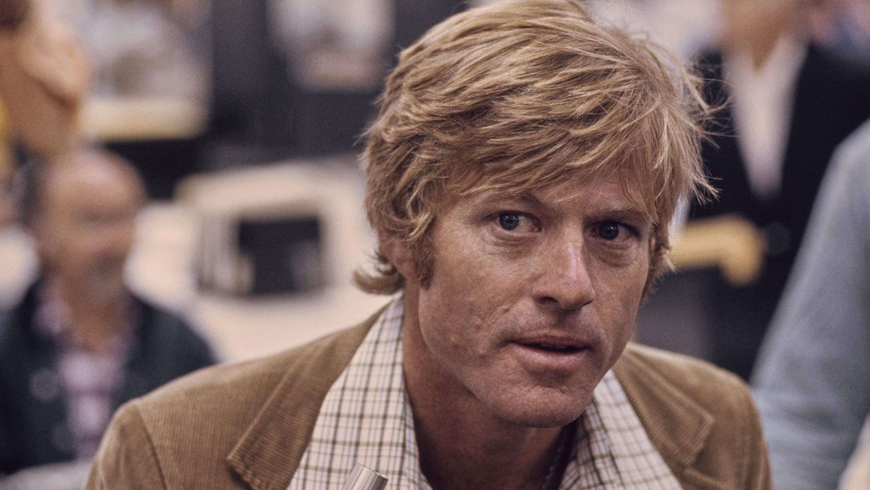American actor Robert Redford, wearing a brown corduroy blazer over a checked shirt, in a recreation of The Washington Post's offices, in a publicity still for 'All the President's Men', filmed at Burbank Studios in Burbank, California, 1976. The political thriller based on the Watergate scandal, directed by Alan J Pakula, starred Redford as Bob Woodward. (Photo by Michael Ochs Archives/Getty Images)