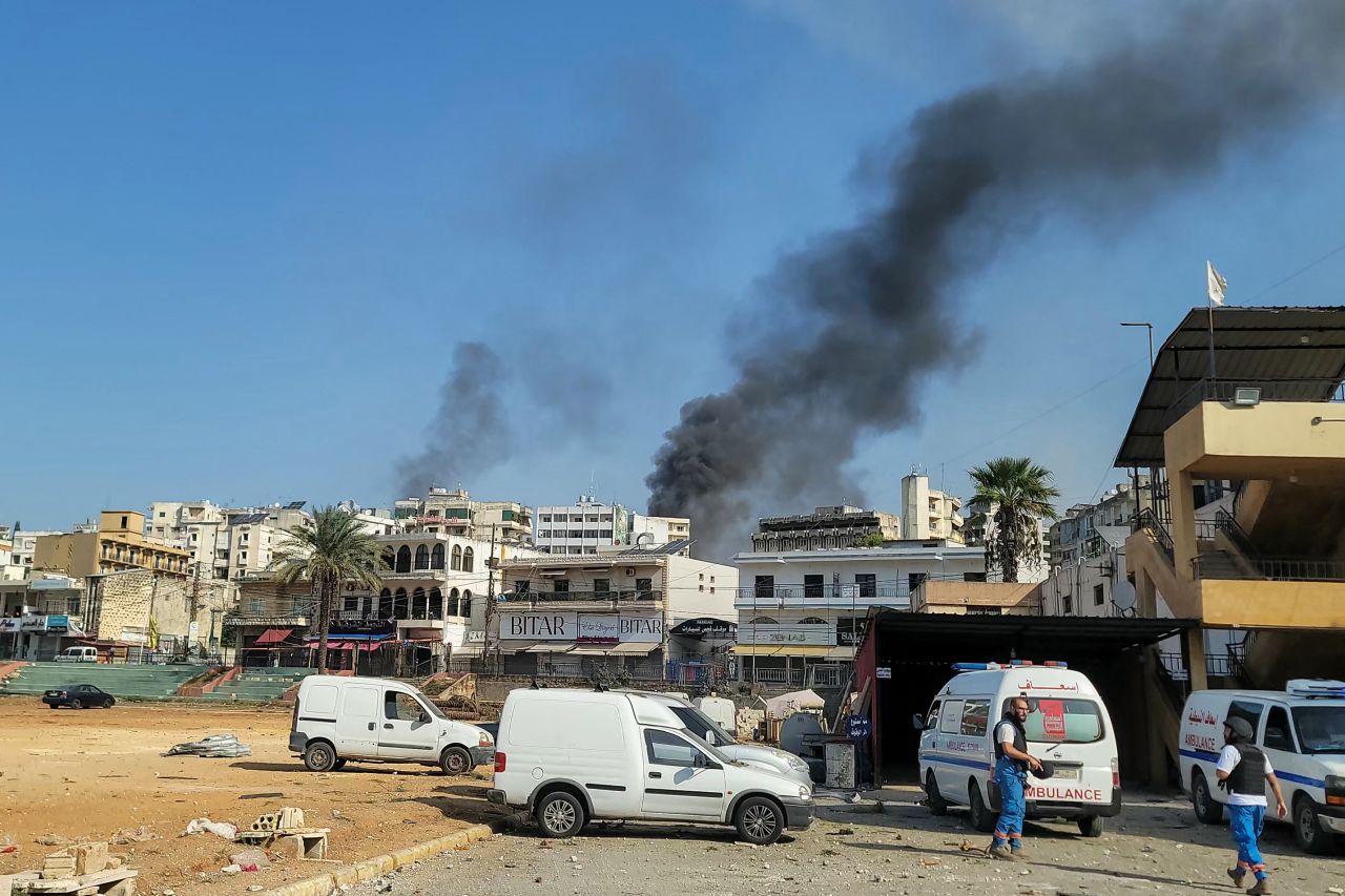 Rescuers at an emergency services center react as smoke billows during Israeli airstrikes in the southern Lebanese city of Nabatiyeh on Wednesday, October 16.