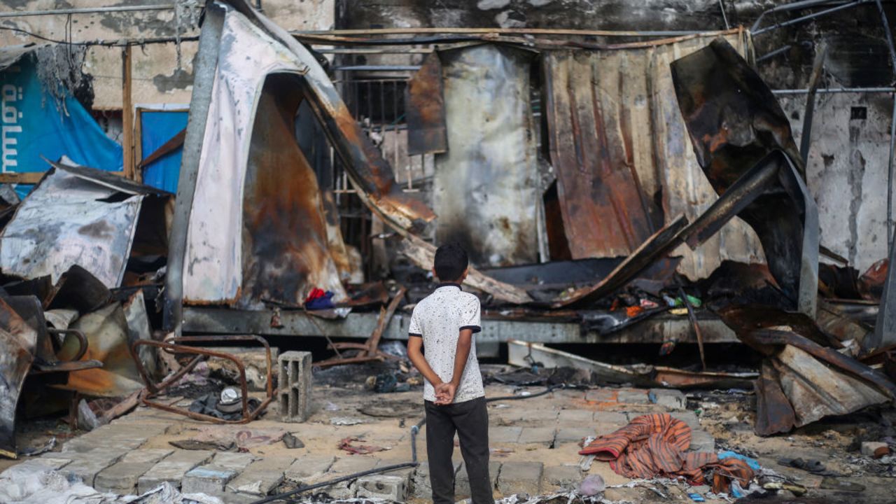 TOPSHOT - A Palestinian boy looks at destroyed shelters at the site of an Israeli airstrike which hit tents for displaced people two days earlier in the courtyard of Al-Aqsa Martyrs Hospital in Deir al-Balah in the central Gaza Strip on October 16, 2024. A spokesman for the Palestinian Civil Defence in Gaza said the October 14 strike had killed four people and wounded many more, noting it was the seventh time an attack had hit the "tents for displaced people inside the walls of Al-Aqsa Martyrs Hospital". (Photo by Eyad BABA / AFP) (Photo by EYAD BABA/AFP via Getty Images)