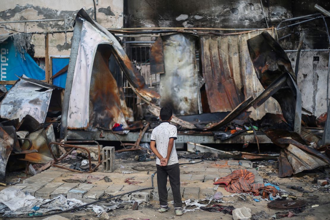 TOPSHOT - A Palestinian boy looks at destroyed shelters at the site of an Israeli airstrike which hit tents for displaced people two days earlier in the courtyard of Al-Aqsa Martyrs Hospital in Deir al-Balah in the central Gaza Strip on October 16, 2024. A spokesman for the Palestinian Civil Defence in Gaza said the October 14 strike had killed four people and wounded many more, noting it was the seventh time an attack had hit the "tents for displaced people inside the walls of Al-Aqsa Martyrs Hospital". (Photo by Eyad BABA / AFP) (Photo by EYAD BABA/AFP via Getty Images)