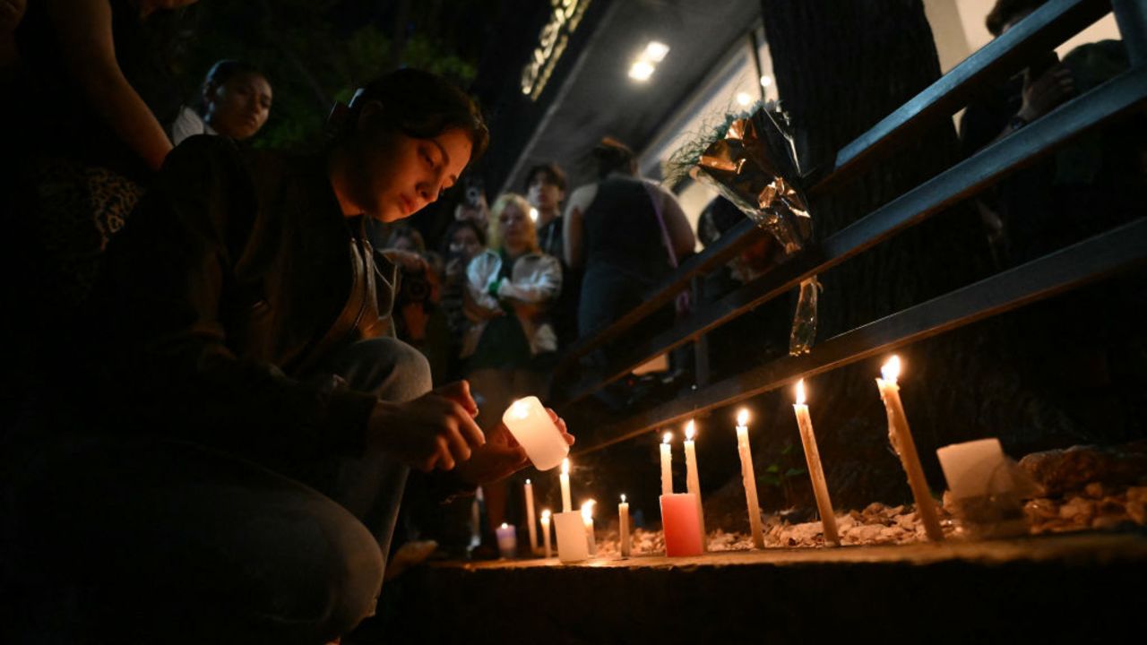 A fan of British singer Liam Payne lit a candle next to the hotel where he died in Buenos Aires on October 16, 2024. British singer Liam Payne, former member of the group One Direction, died Wednesday aged 31 after falling from the third floor of a hotel in Argentina, police in Buenos Aires said. (Photo by Luis ROBAYO / AFP) (Photo by LUIS ROBAYO/AFP via Getty Images)