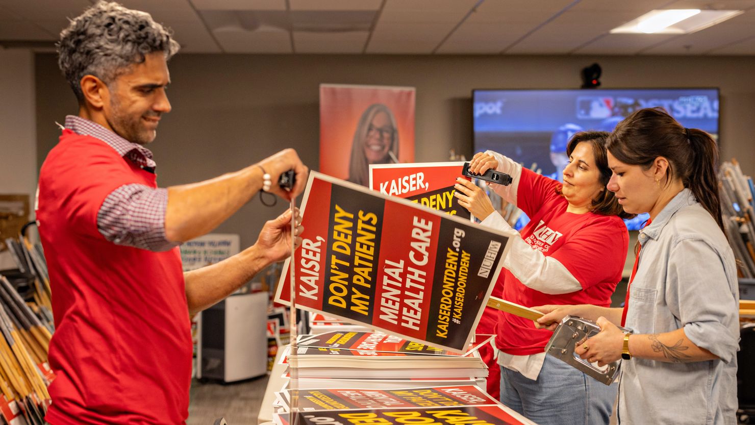 From Left - Edan Dhanrj, Astrid Campos and Rachel Forgash along with other members of the National Union of Healthcare Workers make signs at a Glendale union office for a potential strike on Wednesday, Oct. 16, 2024 in Glendale, CA.