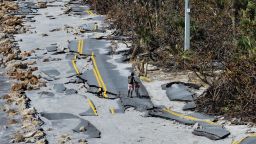 MANASOTA KEY, FLORIDA - OCTOBER 13: In an aerial view, a bicycle rider navigates a damaged road along the Gulf of Mexico on October 13, 2024 in Manasota Key, Florida. People continue recovering following the storm that made landfall as a Category 3 hurricane in the Siesta Key area of Florida on October 9th, causing damage and flooding throughout Central Florida. (Photo by Joe Raedle/Getty Images)