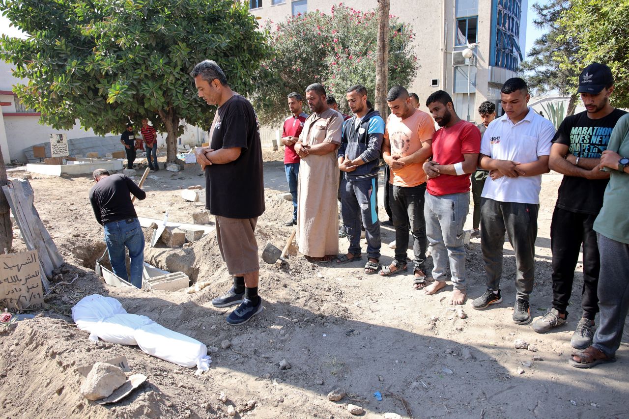 Relatives pray by the shrouded body of 10-year-old Sama al-Debs who was killed by Israel during an army operation in the Jabalya refugee camp in Gaza, during her funeral on October 18.