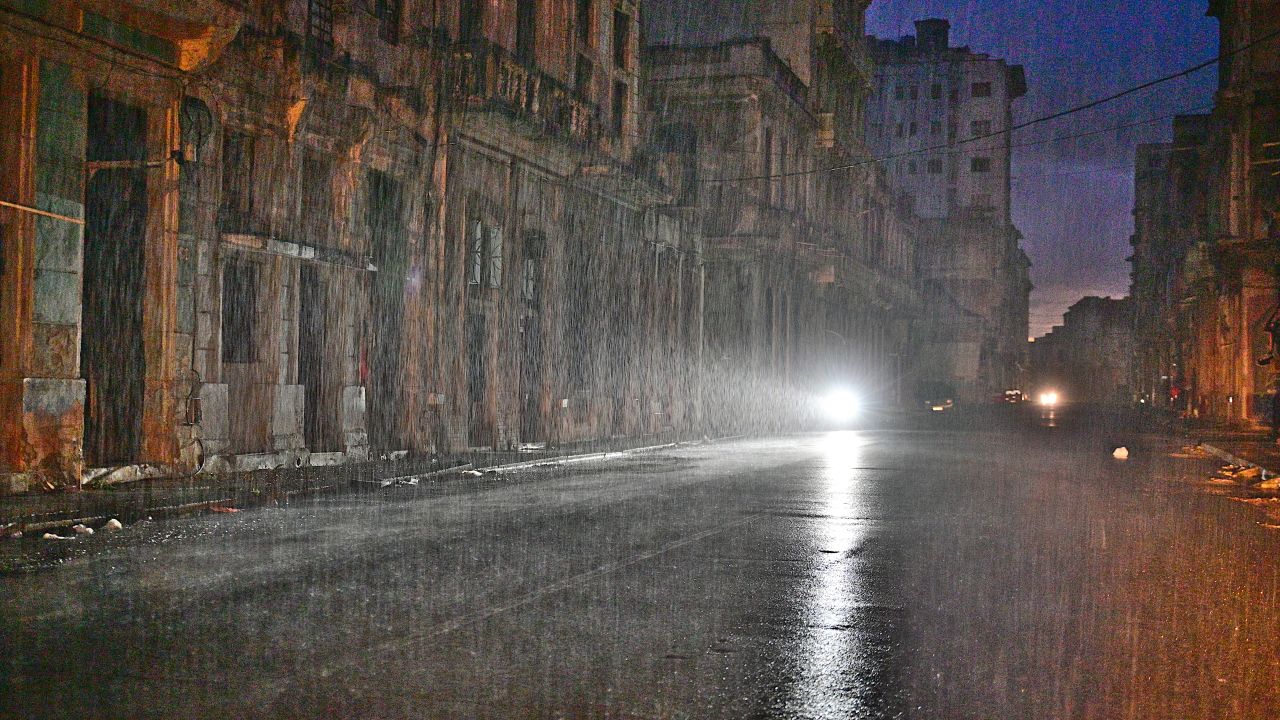 TOPSHOT - A motorcycle lights a street under pouring rain during a nationwide blackout caused by a grid failure in Havana, on October 19, 2024. Technical breakdowns, fuel shortages and high demand have caused the country's thermoelectric power plants to constantly fail, forcing the government to declare an energy emergency and take measures such as closing schools and factories. (Photo by ADALBERTO ROQUE / AFP) (Photo by ADALBERTO ROQUE/AFP via Getty Images)