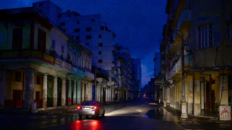 A car drives along a street during a nationwide blackout caused by a grid failure in Havana, on October 19, 2024. Technical breakdowns, fuel shortages and high demand have caused the country's thermoelectric power plants to constantly fail, forcing the government to declare an energy emergency and take measures such as closing schools and factories.