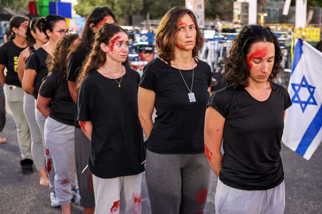 Demonstrators dressed up as Naama Levy, an abducted Israeli army soldier, walk during a re-enactment in Tel Aviv, Israel, on October 19.