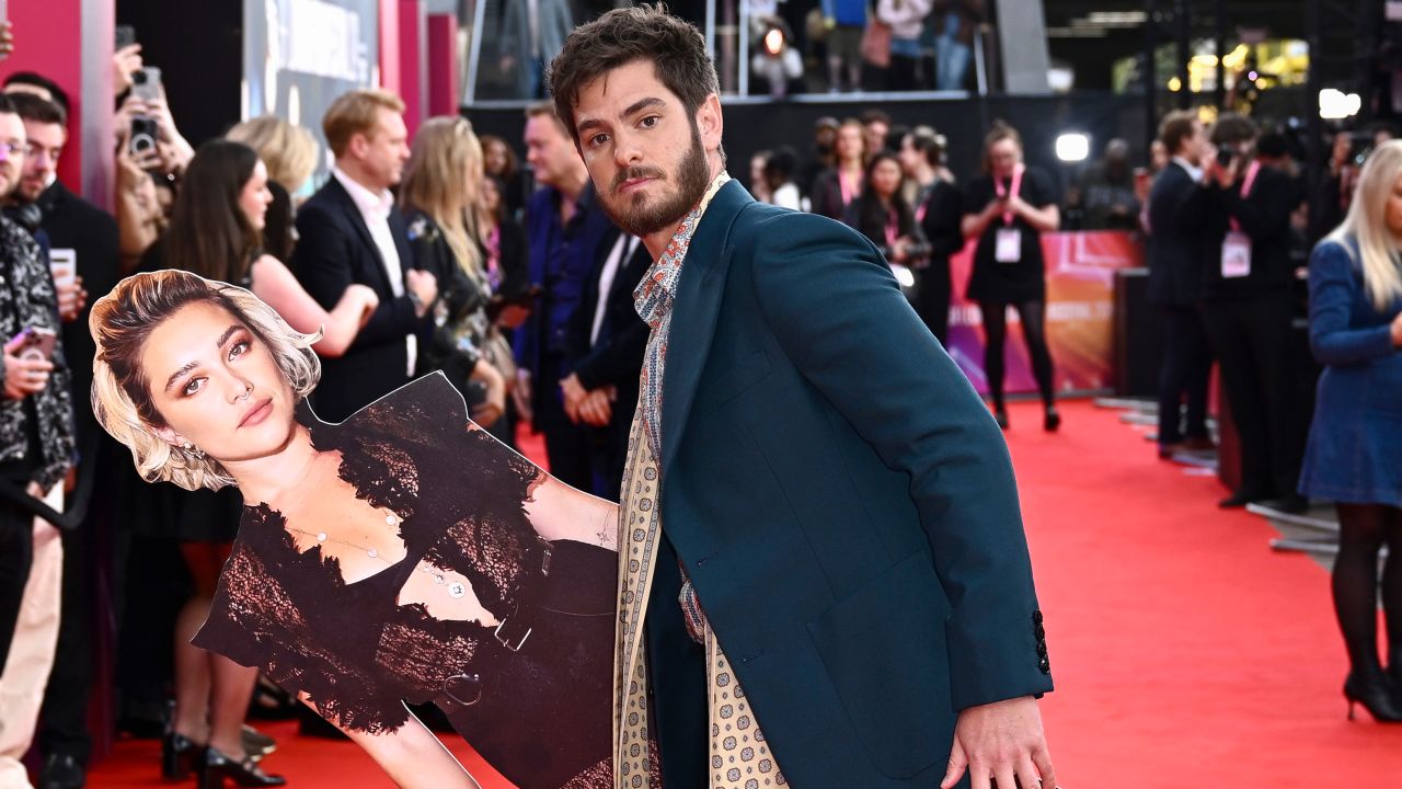 Andrew Garfield poses with a cardboard cutout of Florence Pugh in 