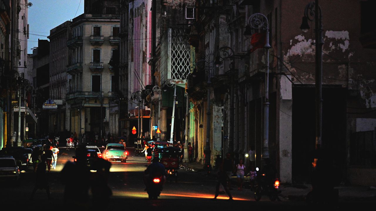 A street is lit by car lights during the third night of a nationwide blackout in Havana October 20, 2024. Cuban President Miguel Diaz-Canel warned Sunday that he will act with "rigor" against those who try to disrupt public order, amid a total blackout that has kept the island in darkness for three nights. (Photo by ADALBERTO ROQUE / AFP) (Photo by ADALBERTO ROQUE/AFP via Getty Images)