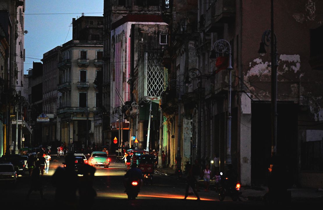 A street is lit by car lights during the third night of a nationwide blackout in Havana, Cuba on October 20, 2024.