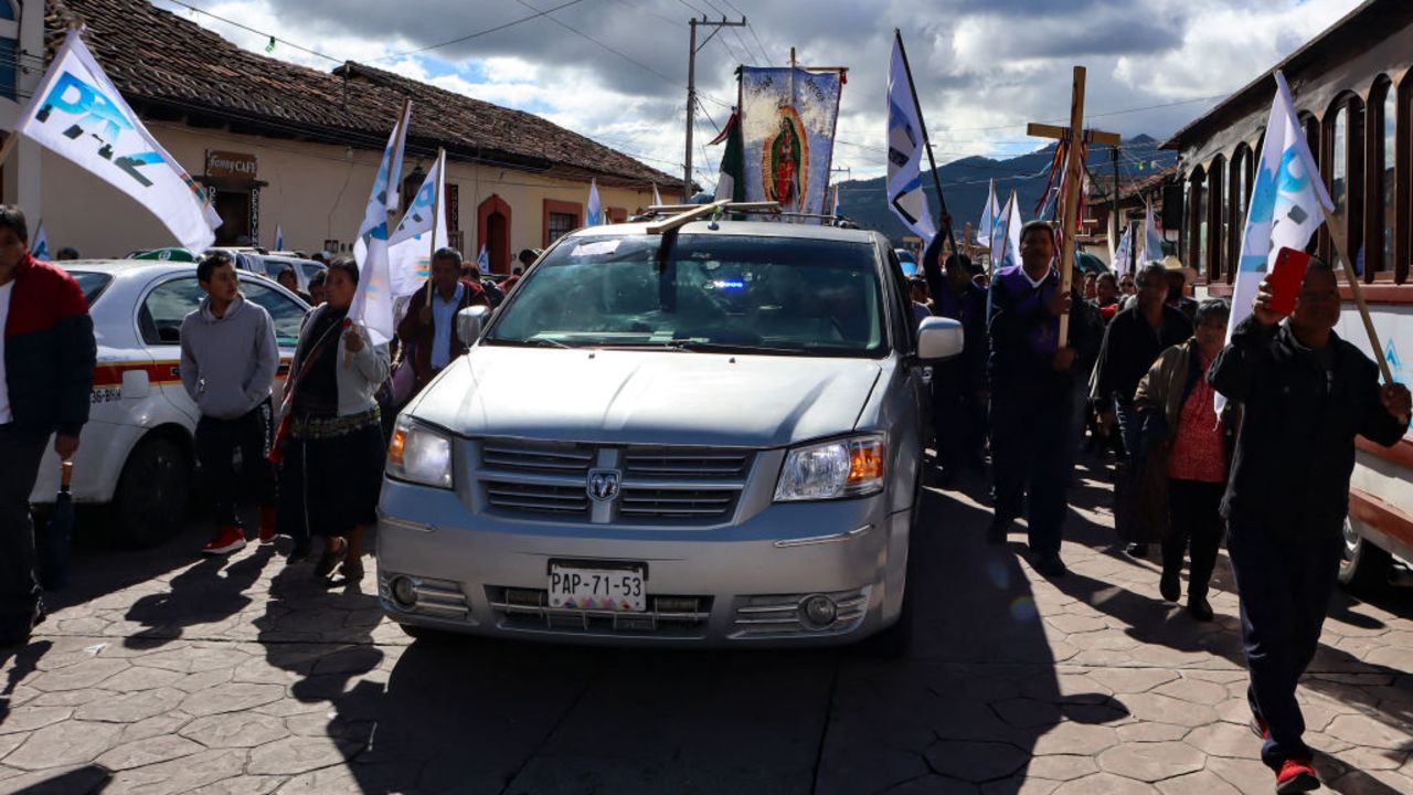 People walk next to the hearse of Catholic priest Marcelo Perez during his wake after he was shot dead in San Cristobal de Las Casas, Chiapas state, Mexico on October 20, 2024. Priest Marcelo Perez, a well-known human rights defender who denounced violence linked to drug trafficking in Mexico, was shot dead on October 20 in San Cristobal de las Casas. (Photo by Claudia Garcia Blanca / AFP) (Photo by CLAUDIA GARCIA BLANCA/AFP via Getty Images)