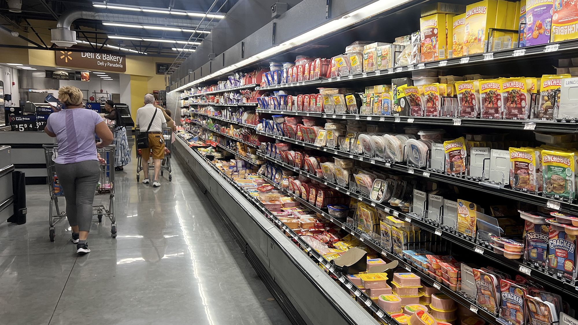 Customers shop in the deli meat aisle of a grocery store on October 17 in Miami.