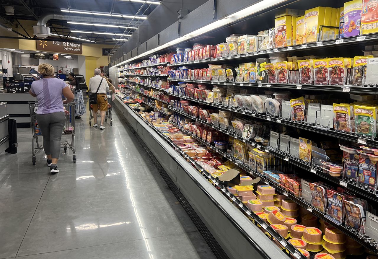 Customers shop in the deli meat aisle of a grocery store on October 17 in Miami, Florida.