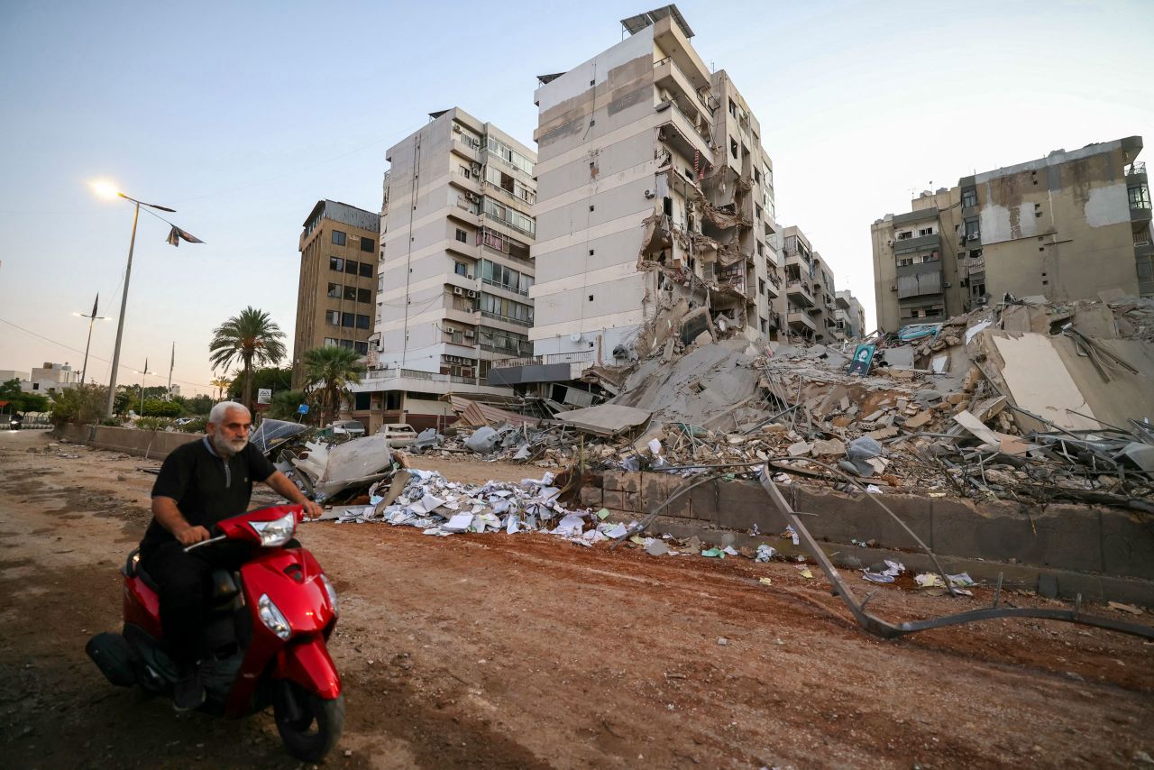 A man rides past destroyed buildings on Tuesday at the site of an overnight airstrike in Beirut.