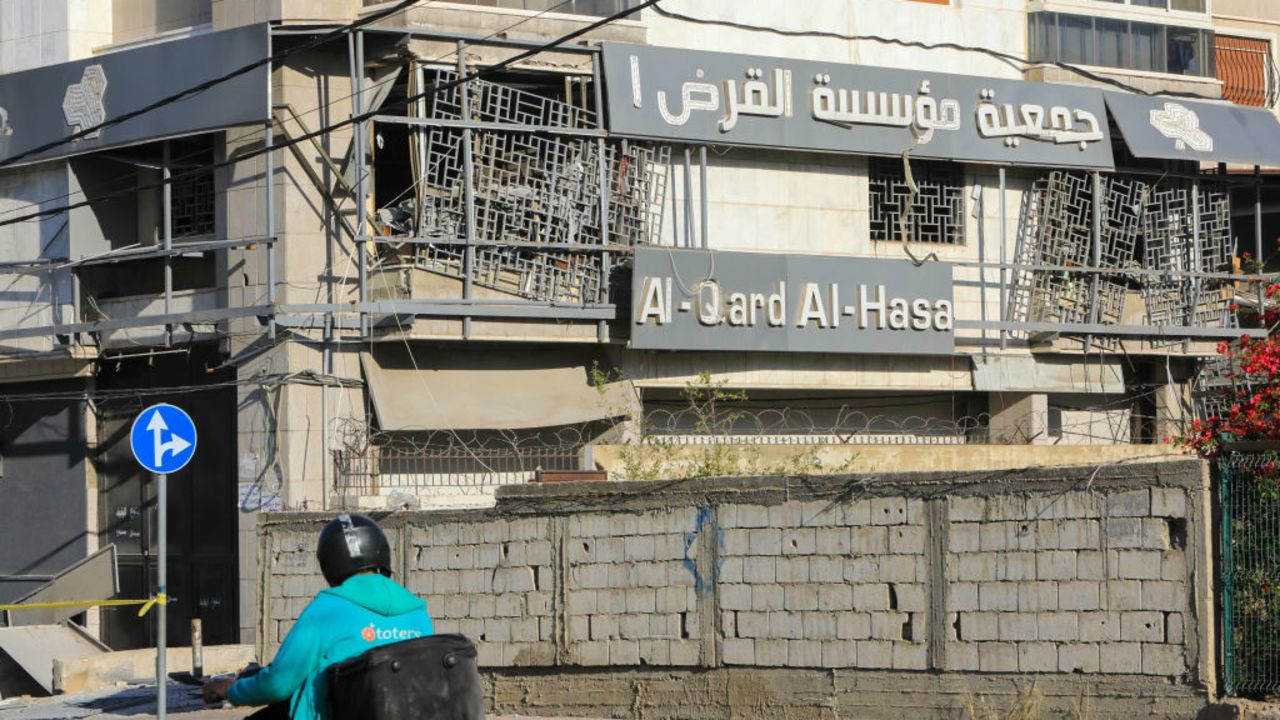 A man rides his moped past the site of an overnight Israeli airstrike that targetted a branch of the Al-Qard Al-Hassan finance group in Beirut's southern suburbs on October 21, 2024, amid the ongoing war between Israel and Hezbollah. Israel began bombing Lebanese branches of an association accused of financing the Iran-backed Hezbollah movement, Lebanese state media reported late on October 20, in a further escalation of Israel's nearly month-long war against the militants. (Photo by AFP) (Photo by -/AFP via Getty Images)