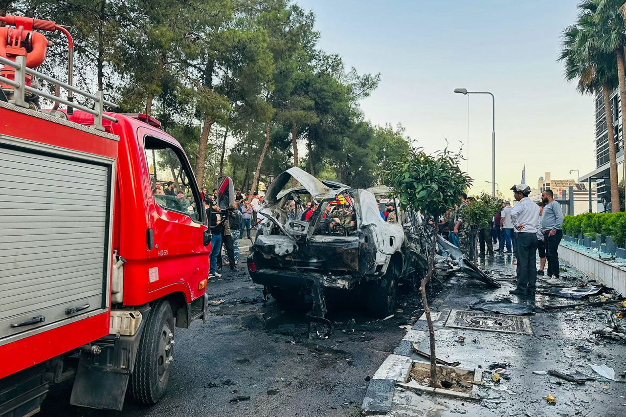 Syrian emergency and security services inspect the wreckage of a car that exploded in Damascus on Monday, October 21.