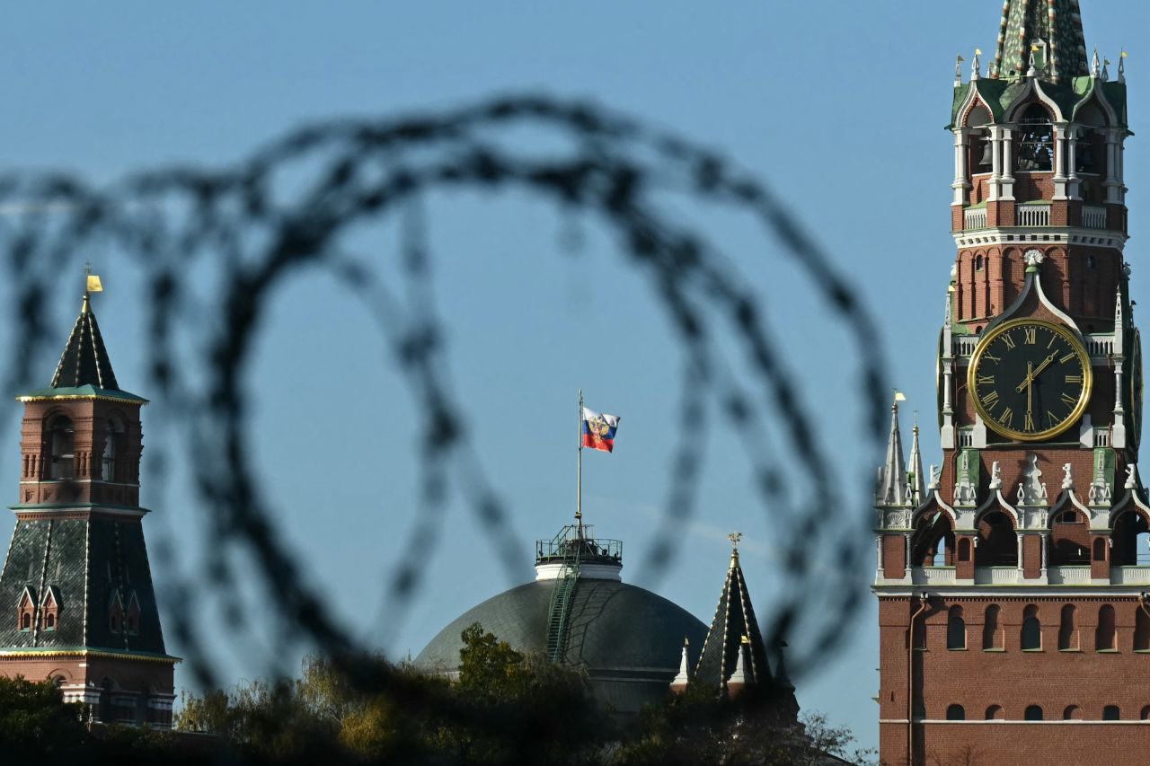 The Russian flies on top of the dome of the Senate Palace, one of the main buildings within the Kremlin compound, as seen through a barbed wire in Moscow on October 22.