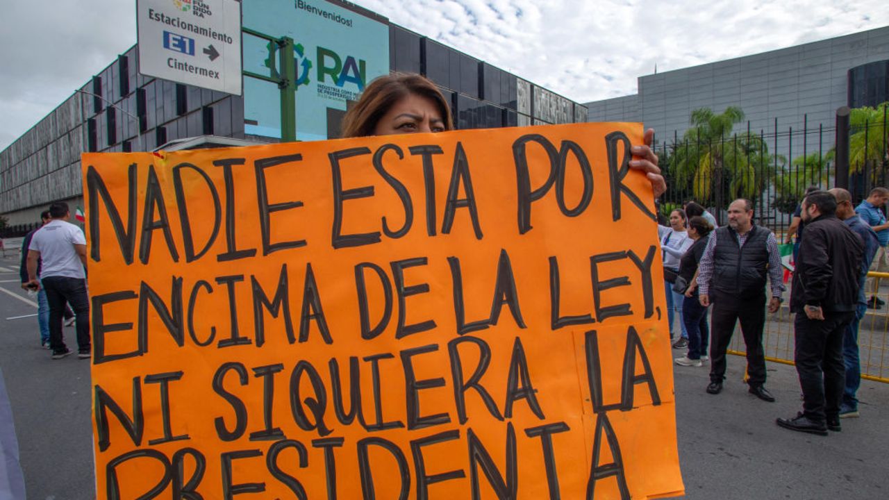 A woman holds a sign that reads "No one is above the law, not even the President" during a protest against the judicial reform outside the International Business Center in Monterrey, Nuevo Leon State, Mexico, on October 22, 2024. (Photo by Julio Cesar AGUILAR / AFP) (Photo by JULIO CESAR AGUILAR/AFP via Getty Images)