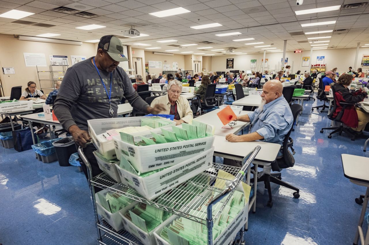 Election workers open envelopes and sort through ballots at the Maricopa County Tabulation and Election Center in Phoenix on October 23.