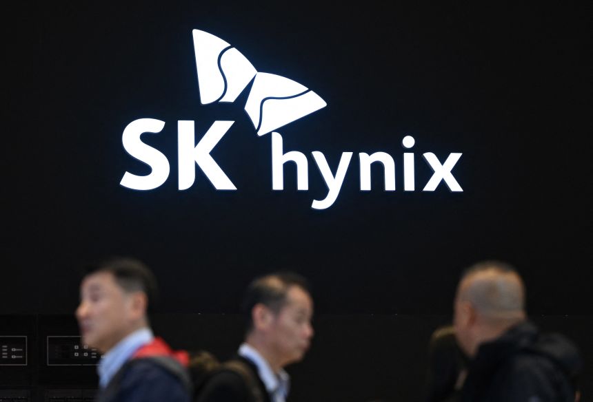 People walk past the logo of SK hynix during a semiconductor exhibition at the COEX convention and exhibition centre in Seoul on October 24, 2024.