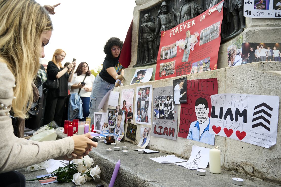 Flowers, photos and candles are displayed in honor of Liam Payne during a memorial gathering at Santa Ana Square on October 20, 2024 in Madrid, Spain.