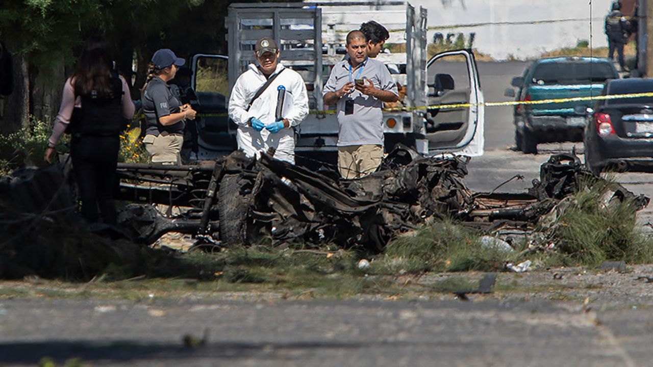 Forensic experts work at the site of a bomb car blast in front of the municipal Public Security Secretariat, which left three municipal police officers injured, in the municipality of Acambaro, state of Guanajuato, Mexico, on October 24, 2024. (Photo by Enrique CASTRO / AFP) (Photo by ENRIQUE CASTRO/AFP via Getty Images)