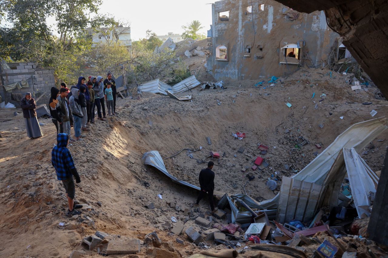 People inspect the damage at the site of an Israeli strike in Khan Younis, Gaza, on Friday.