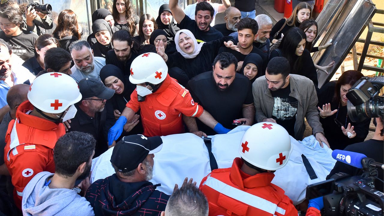 Relatives and colleagues of three journalists killed in an Israeli strike in the southern Lebanese village of Hasbaiya gather around a Red Cross ambulance as their bodies arrive at a hospital in Beirut on October 25.
