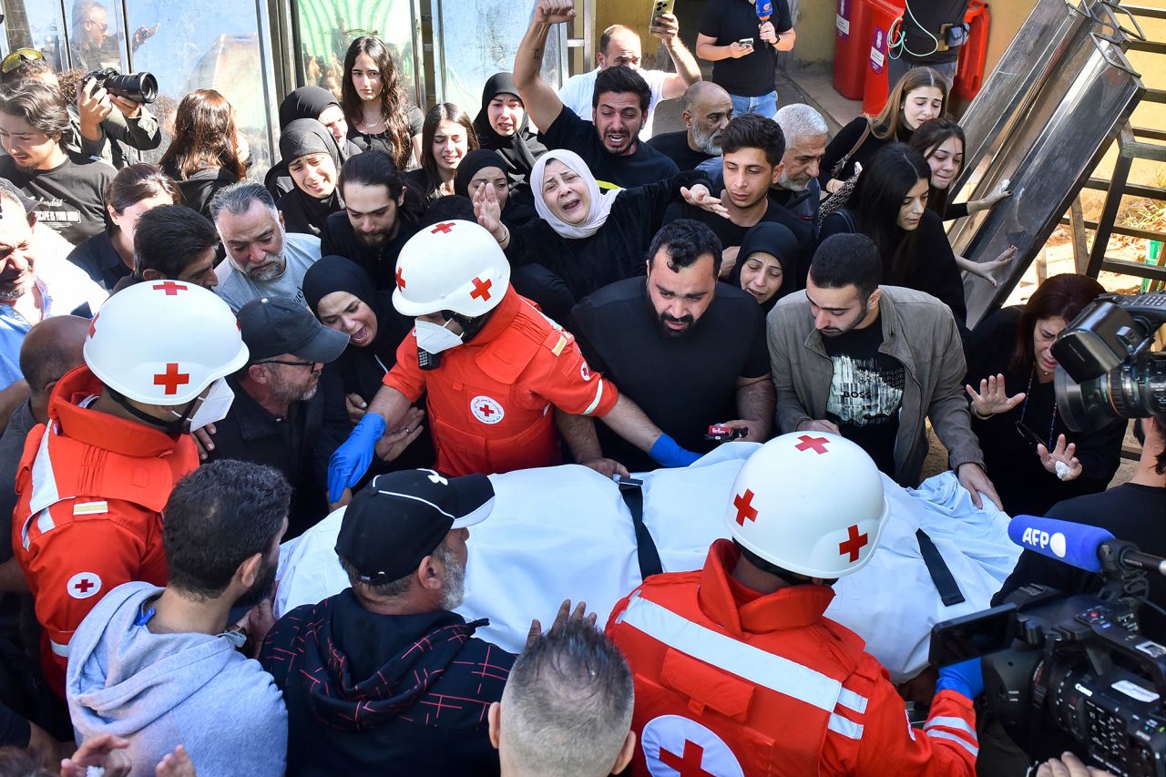 Relatives and colleagues of three journalists killed in an Israeli strike in the southern Lebanese village of Hasbaiya gather around a Red Cross ambulance as their bodies arrive at a hospital in Beirut on October 25.