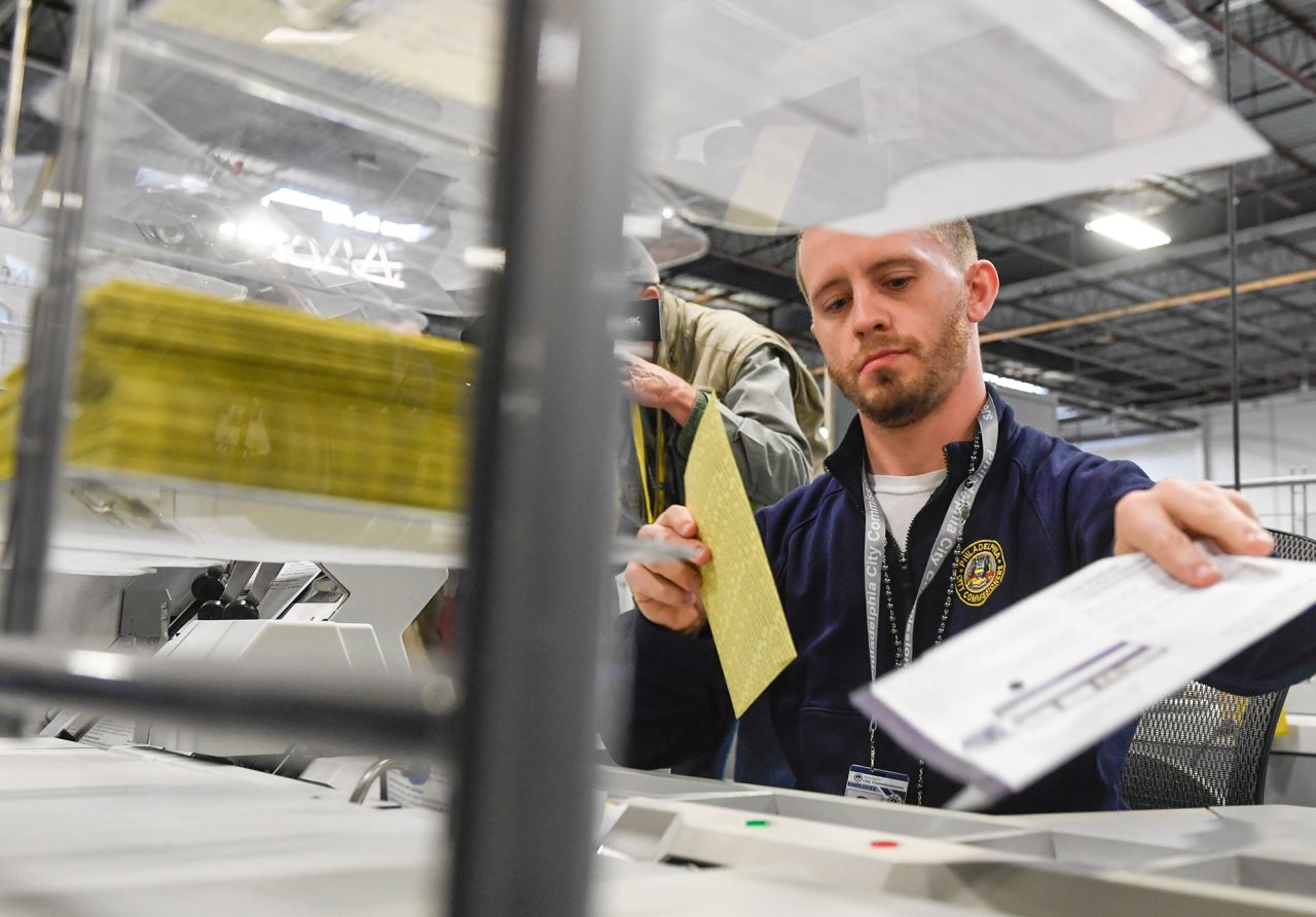 Poll workers demonstrate how ballots will be processed on election day during a press tour of the Philadelphia election warehouse on October 25.