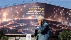 A man walks past an anti-Israel billboard covering the facade of a building in Tehran on October 26, 2024. Residents of Tehran awoke and went about their business as planned on October 26 after their sleep was troubled by Israeli strikes that triggered blasts that echoed across the city. (Photo by ATTA KENARE / AFP) (Photo by ATTA KENARE/AFP via Getty Images)