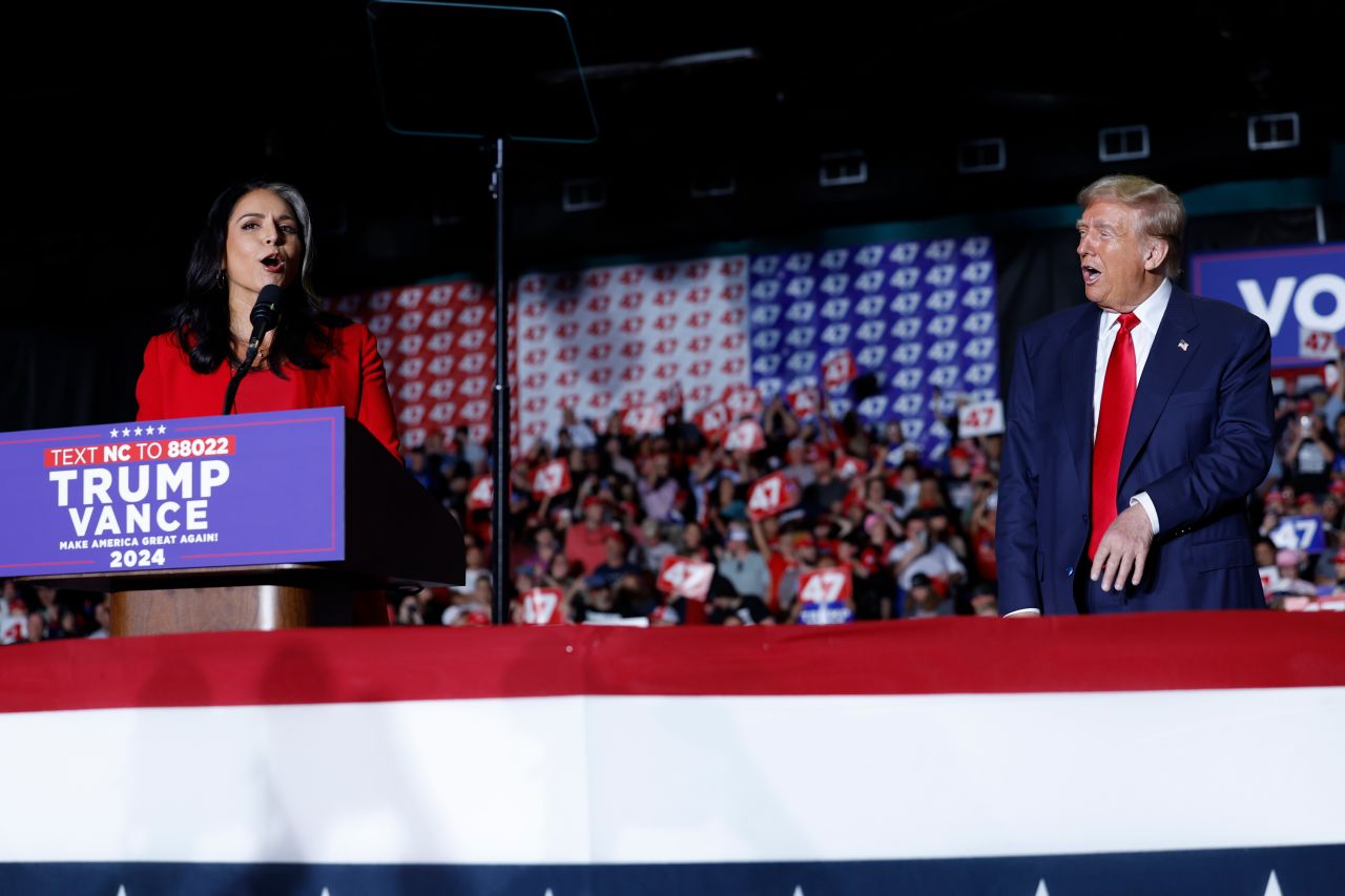 Former US Representative Tulsi Gabbard announces that she is joining the Republican party as Donald Trump reacts to her speaking at a campaign rally in Greensboro, North Carolina, on October 22.