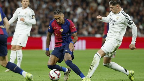 Barcelona's Brazilian forward #11 Raphinha and Real Madrid's Uruguayan midfielder #08 Federico Valverde (R) vie for the ball during the Spanish league football match between Real Madrid CF and FC Barcelona at the Santiago Bernabeu stadium in Madrid on October 26, 2024. (Photo by OSCAR DEL POZO / AFP) (Photo by OSCAR DEL POZO/AFP via Getty Images)
