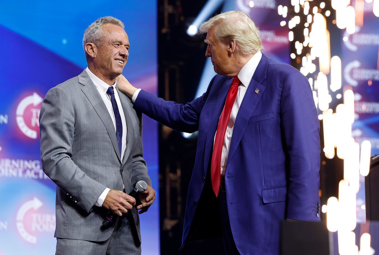 Republican presidential nominee, former President Donald Trump welcomes Robert F. Kennedy Jr. to the stage at a Turning Point Action campaign rally at the Gas South Arena in Duluth, Georgia, on October 23, 2024.