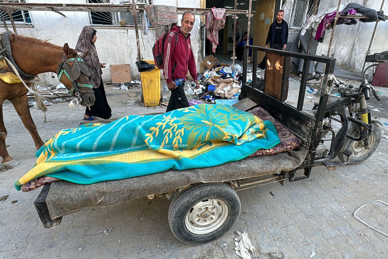 A body covered with a blanket lies on a cart outside the Kamal Adwan Hospital in Beit Lahiya, Gaza, after an Israeli attack on October 28.