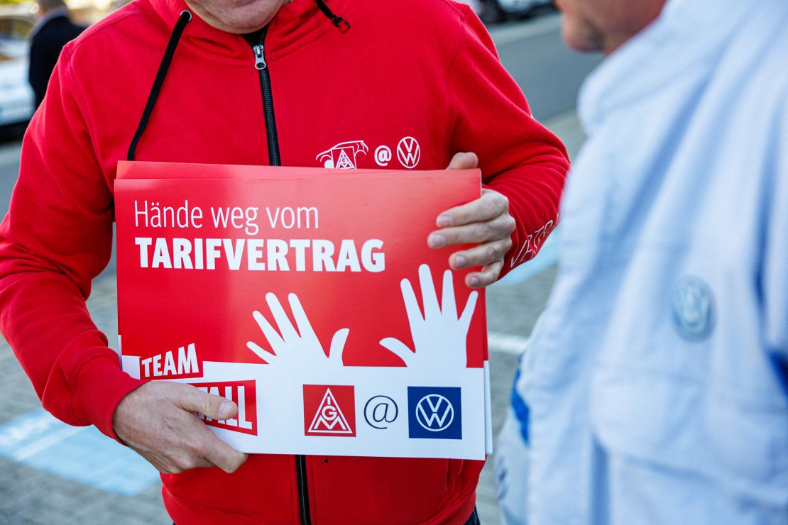 A Volkswagen employee holds a placard reading "Hands off the collective agreement" during a VW works council event in Zwickau, eastern Germany on October 28, 2024.