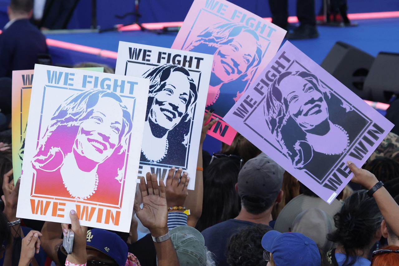 Supporters of Democratic presidential nominee Vice President Kamala Harris, hold signs during a campaign event with former President Barack Obama at the James R Hallford Stadium in Clarkston, Georgia, on October 24, 2024.