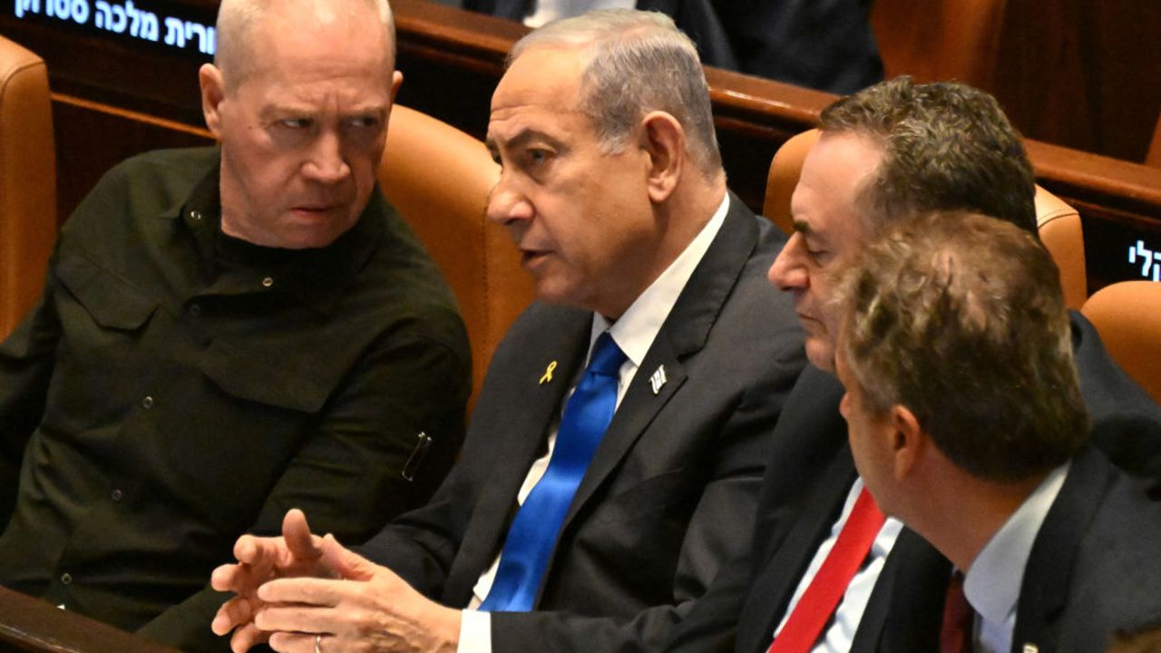 Israeli Prime Minister Benjamin Netanyahu (C) speaks to Defence Minister Yoav Gallant (L) at the opening of the 25th Parliament session in Jerusalem on October 28, 2024. (Photo by DEBBIE HILL / POOL / AFP) (Photo by DEBBIE HILL/POOL/AFP via Getty Images)