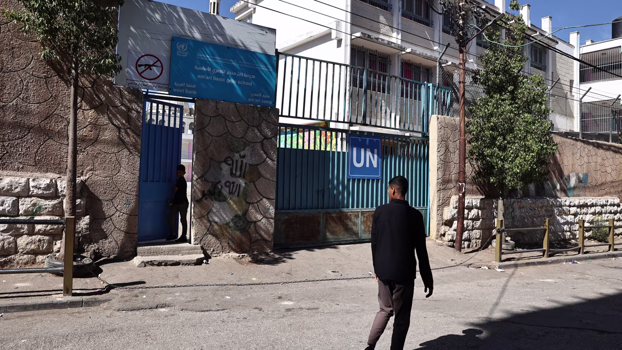 A Palestinian man walks past the UNRWA school in the Al-Amari refugee camp near Ramallah, in the occupied West Bank on October 29.