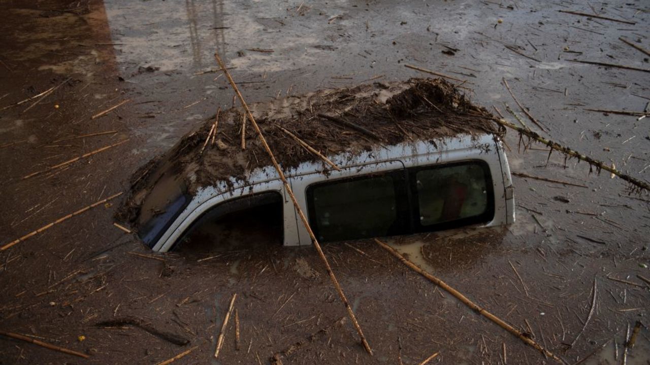 A car covered with mud is pictured on a flooded street in Alora, near Malaga, on October 29, 2024, after a heavy rain hit southern Spain. (Photo by JORGE GUERRERO / AFP) (Photo by JORGE GUERRERO/AFP via Getty Images)