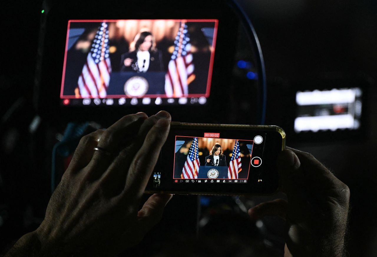 A crowd member takes a video of Kamala Harris during her speech.