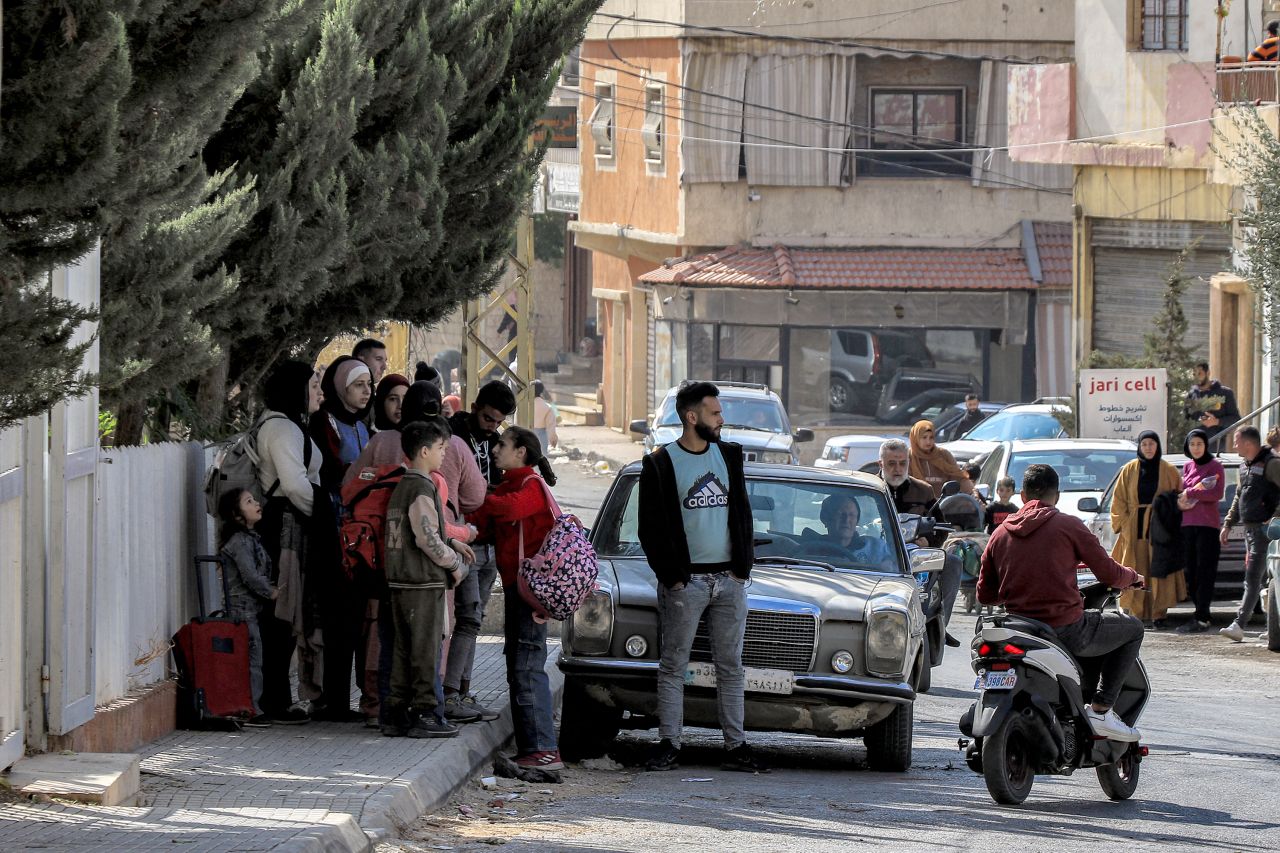 People wait along the side of a road for their ride before evacuating Lebanon's eastern city of Baalbek in the Bekaa Valley on October 30, 2024, after a statement from the Israeli army spokesperson warning residents of incoming strikes. (Photo by Nidal SOLH / AFP) (Photo by NIDAL SOLH/AFP via Getty Images)