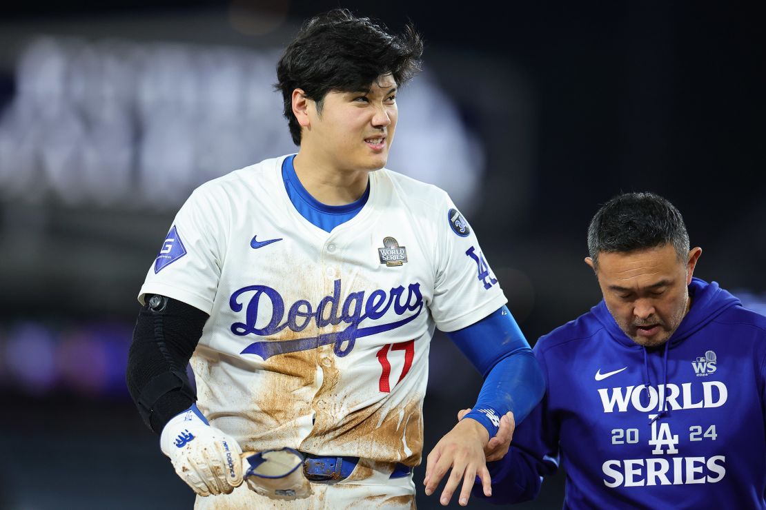 Ohtani leaves the field next to a trainer.