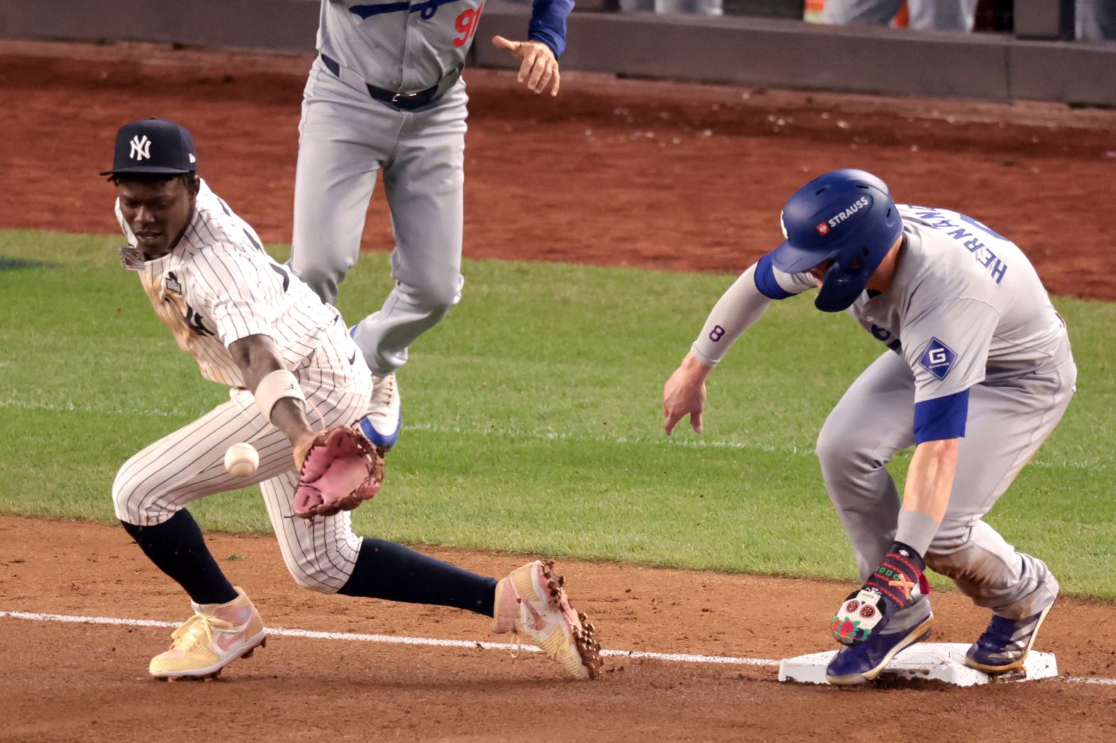 The Dodgers' Enrique Hernández is safe at third base after a throwing error by Yankees shortstop Anthony Volpe in the fifth inning. The error came right after Yankees outfielder Aaron Judge dropped a fly ball in the previous at-bat.