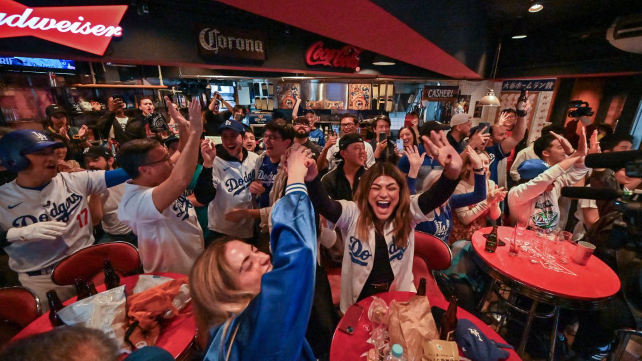 Dodgers fans cheer as their team scores in the 5th inning, at a bar in the Shibuya district of Tokyo on October 31, 2024, during a live broadcast of Game 5 of the US Major League Baseball World Series between the Los Angeles Dodgers and the New York Yankees in New York. (Photo by Richard A. Brooks / AFP) (Photo by RICHARD A. BROOKS/AFP via Getty Images)