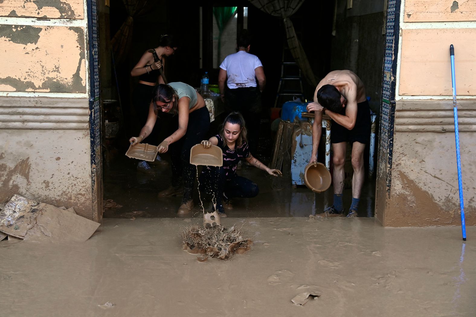 People scoop mud out of a house in La Torre on Thursday.