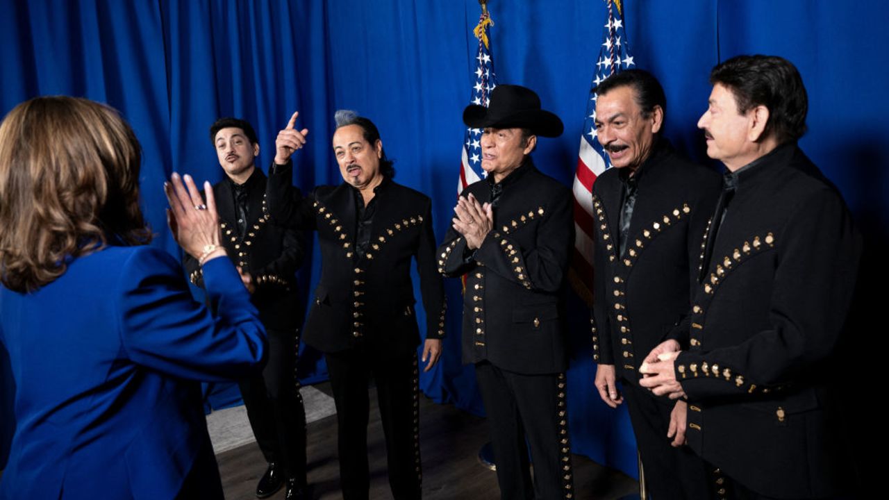 US Vice President Kamala Harris (L) meets with members of Norteno band Los Tigres del Norte before speaking during a campaign rally at Talking Stick Resort Amphitheatre in Phoenix, Arizona, on October 31, 2024. (Photo by Brendan Smialowski / AFP) (Photo by BRENDAN SMIALOWSKI/AFP via Getty Images)