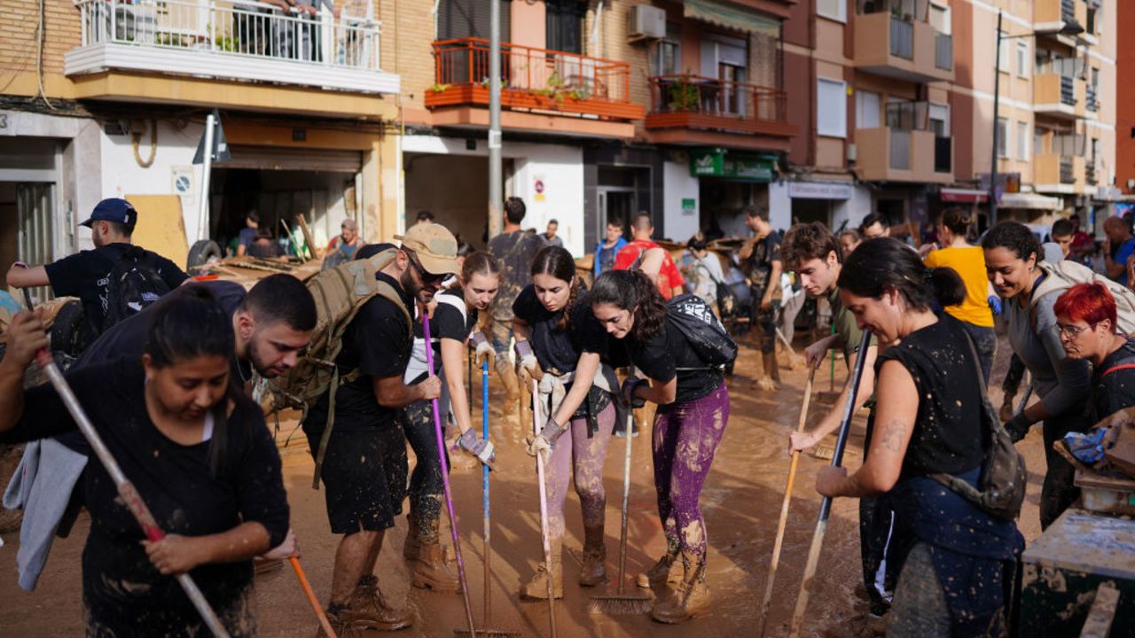 Volunteers and locals clean the street on November 1, 2024, after a flooding devastated the town of Paiporta, in the region of Valencia, eastern Spain. The death toll from Spain's worst floods in a generation has climbed to 205, rescuers said today, with the number expected to rise as more people are believed missing. The agency coordinating emergency services in the eastern Valencia region said 202 people had been confirmed dead there, with officials in Castilla-La Mancha and Andalusia previously announcing a combined three deaths in their regions. (Photo by Manaure Quintero / AFP) (Photo by MANAURE QUINTERO/AFP via Getty Images)