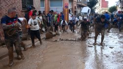 Locals and volunteers remove mudy water, on November 1, 2024, after a flooding devastated the town of Paiporta, in the region of Valencia, eastern Spain. The death toll from Spain's worst floods in a generation has climbed to 205, rescuers said today, with the number expected to rise as more people are believed missing. The agency coordinating emergency services in the eastern Valencia region said 202 people had been confirmed dead there, with officials in Castilla-La Mancha and Andalusia previously announcing a combined three deaths in their regions. (Photo by JOSE JORDAN / AFP) (Photo by JOSE JORDAN/AFP via Getty Images)